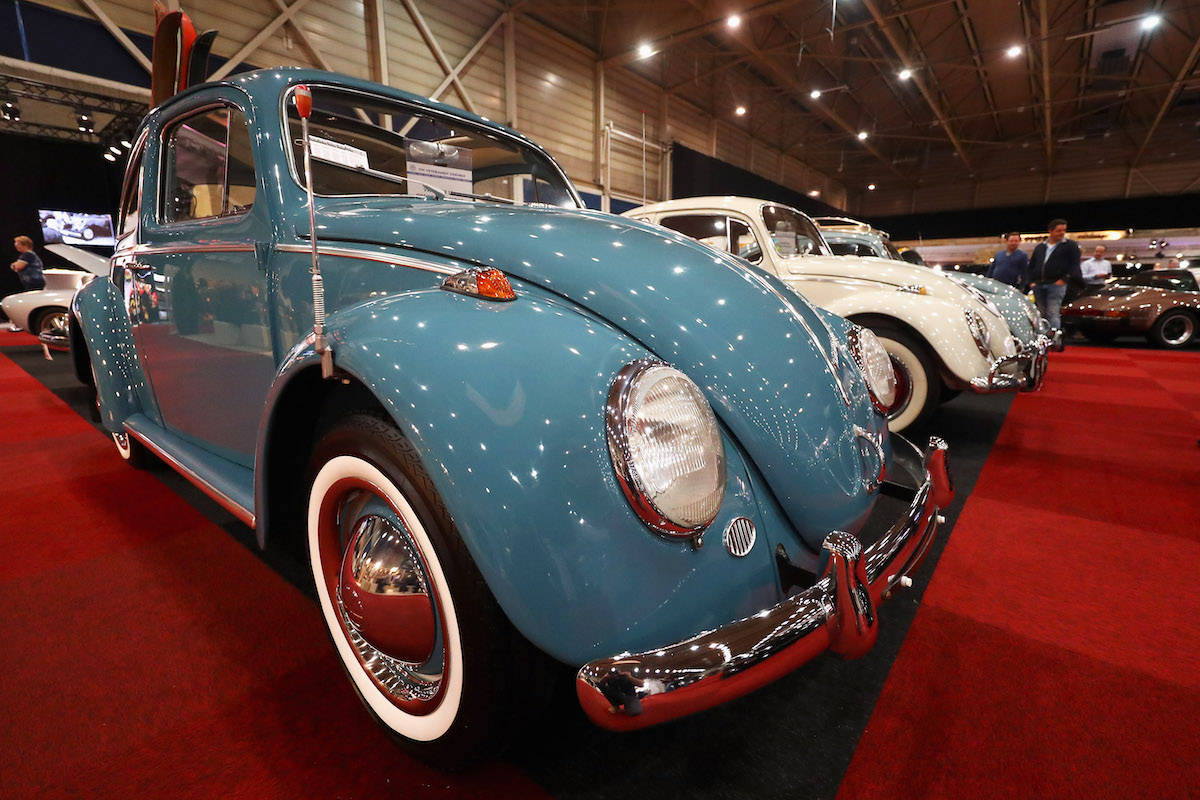 A 1963 Volkswagen Beetle in blue, parked at a car show, the Beetle is included  a million mile car