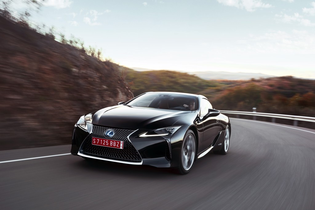 The Lexus LC 500h at speed on a winding scenic road