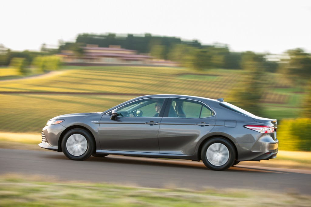 a Toyota Camry, like this gray one driving in the countryside, is a great used car
