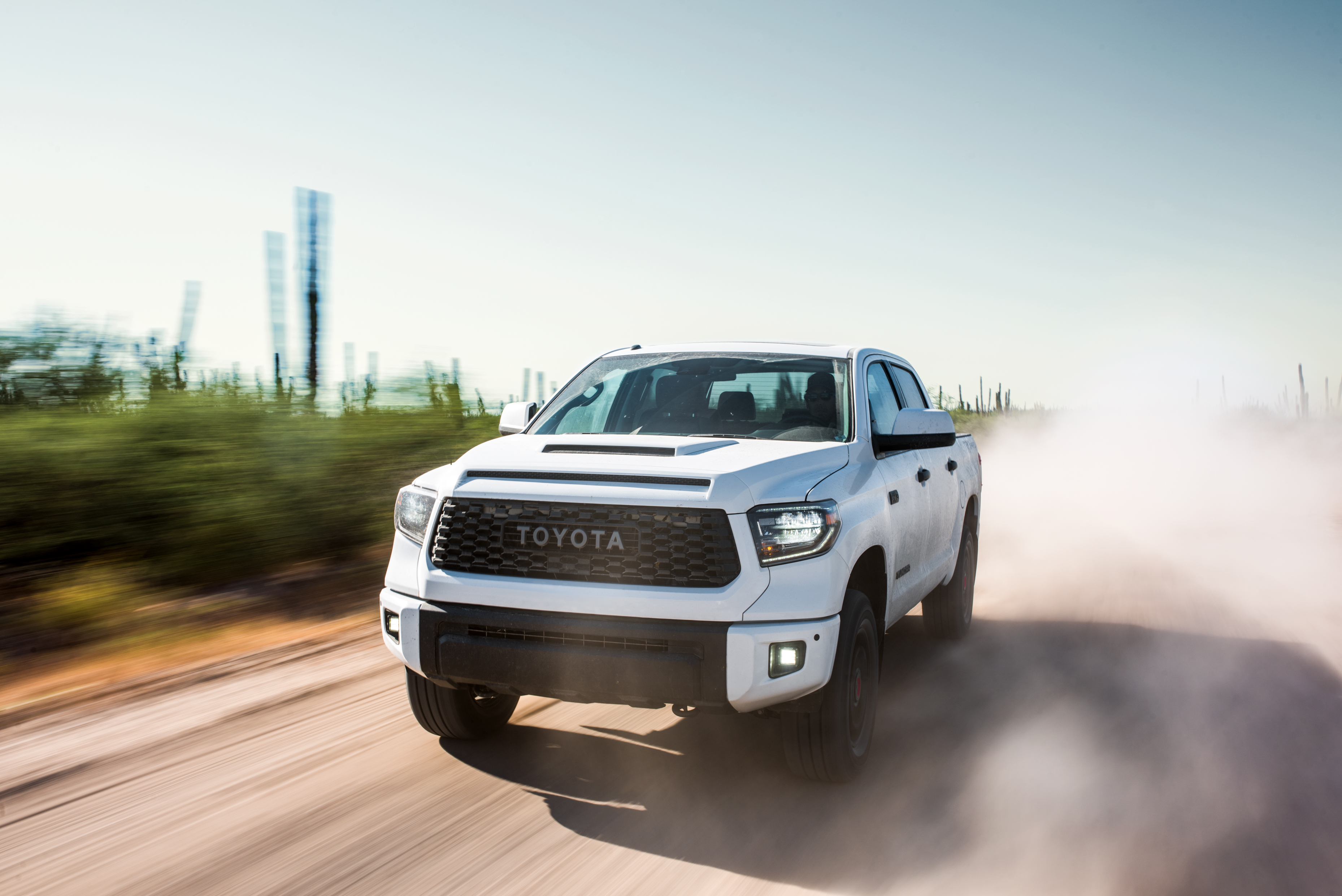 A white Toyota Tundra TRD Pro off-road pickup truck kicking up dirt