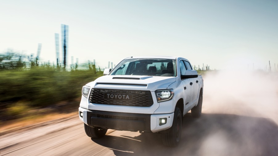 A white Toyota Tundra TRD Pro off-road pickup truck kicking up dirt
