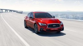 Red 2019 Infiniti Q50 driving down the highway.