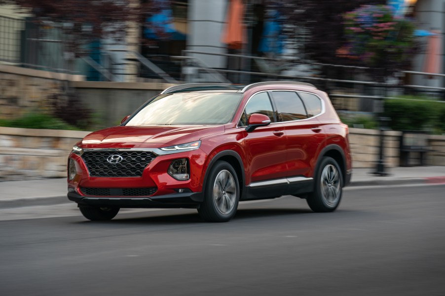 red Hyundai Santa Fe in motion down city street