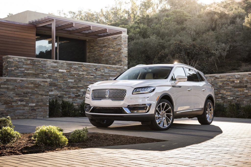 A white Lincoln Nautilus sits on a brick driveway.