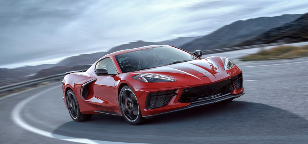 A red 2020 Chevy Corvette rounds a scenic turn.