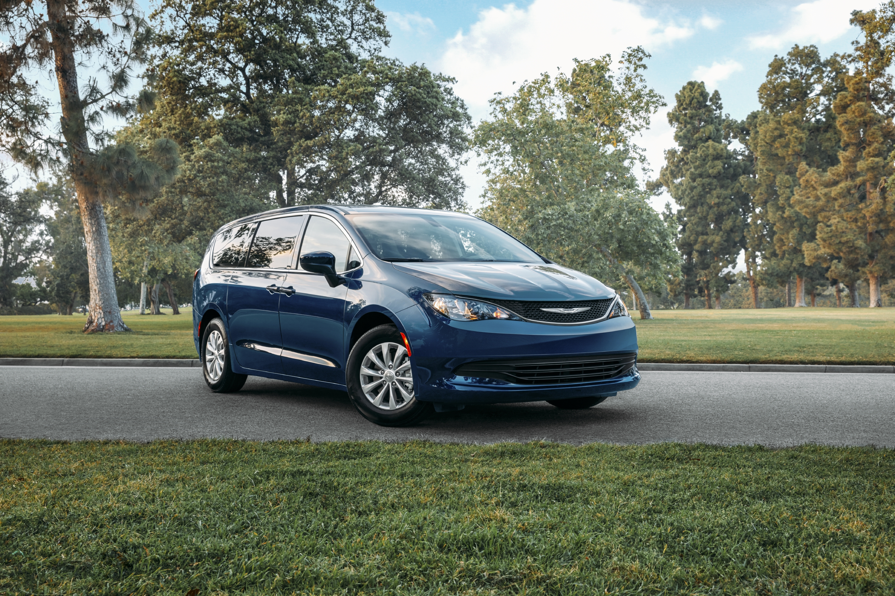 A blue Chrysler Voyager minivan parked on street