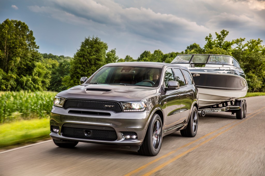 2019 Dodge Durango SRT towing a boat down a country road flaunts its max towing capacity 