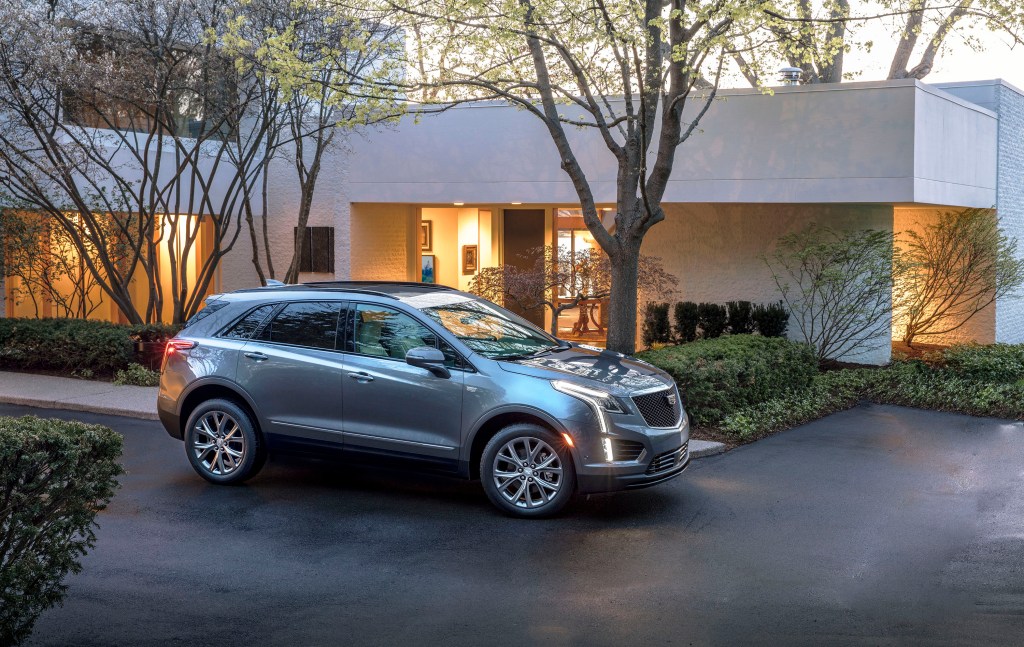 2020 Cadillac XT5 Sport luxury SUV in front of a modern home at dusk