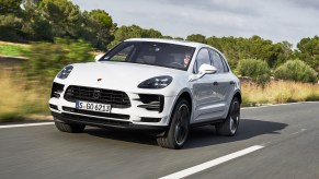A white 2018 Porsche Macan sUV driving down the highway.