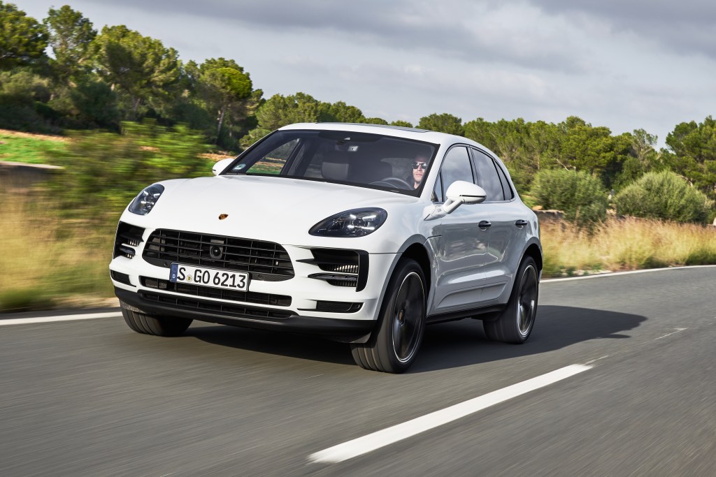 A white 2018 Porsche Macan sUV driving down the highway.