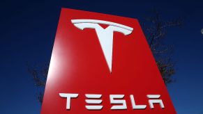 A red Tesla sign towers into the sky