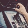 Male hand on gear shift in automatic transmission vehicle