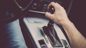 Male hand on gear shift in automatic transmission vehicle