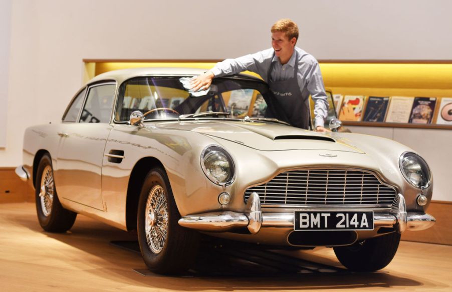 A man washes the front windshield of a 1965 Aston Martin DB5