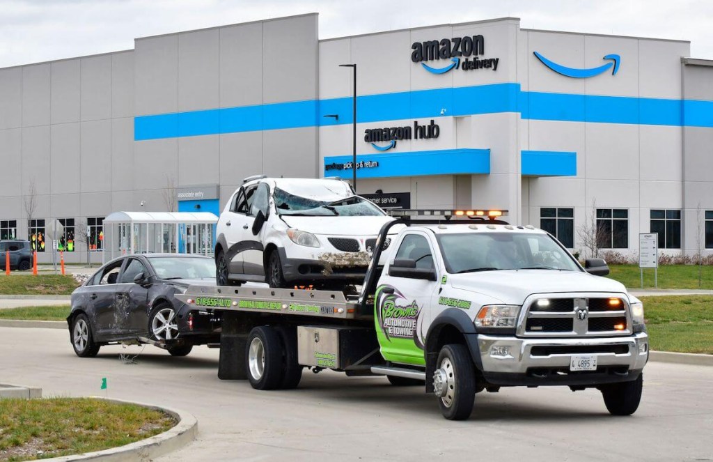 Two cars getting towed by a tow truck