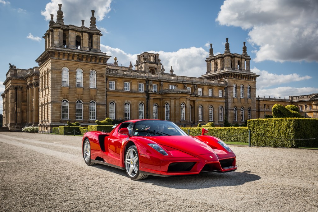 Red 2004 Ferrari Enzo parked in front of a castle