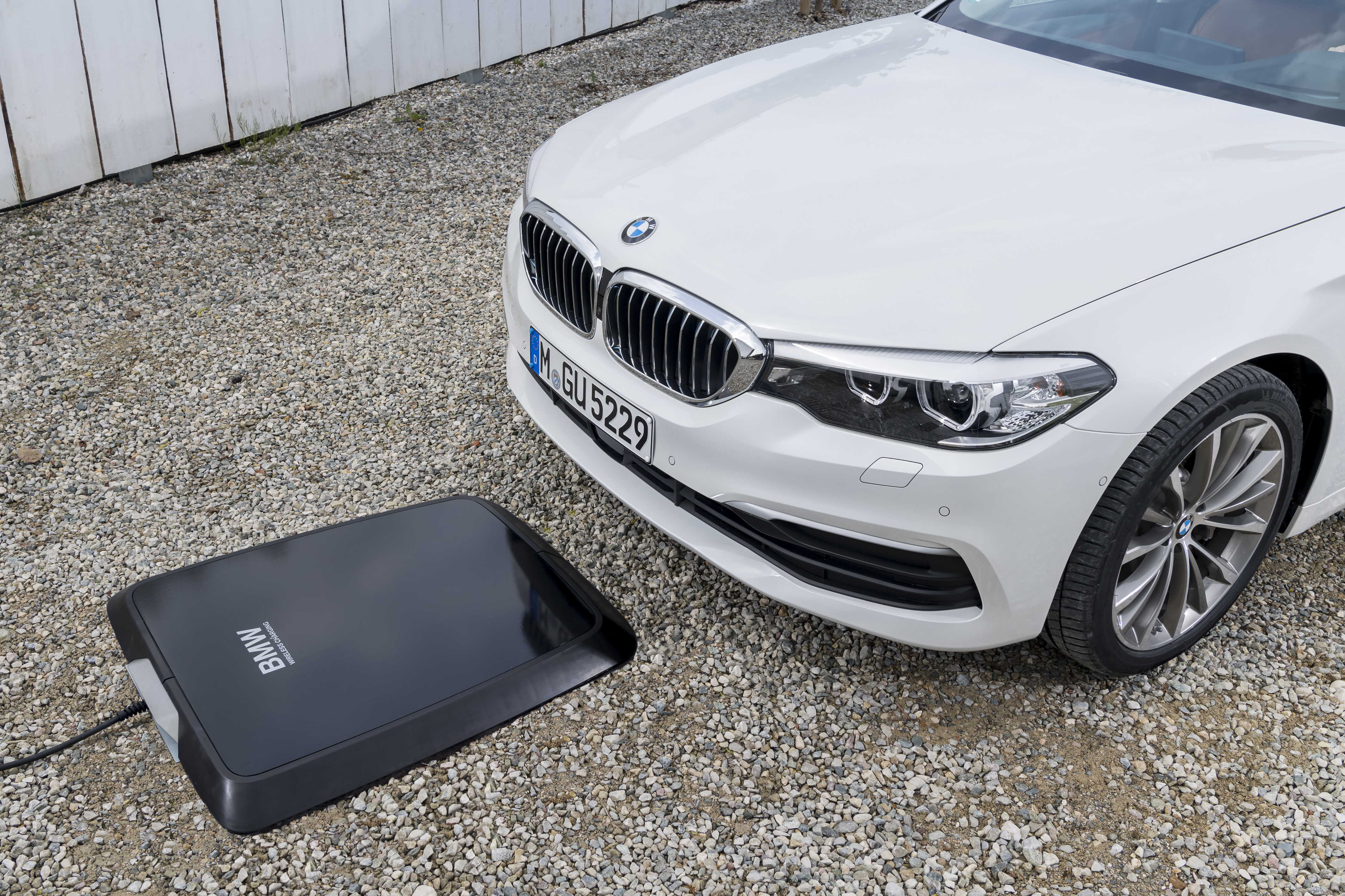 A BMW 530e iPerformance series lines up over an inductive charging station