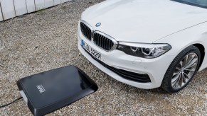 A BMW 530e iPerformance series lines up over an inductive charging station
