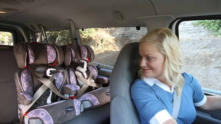 woman drives car with two car seats in the second row