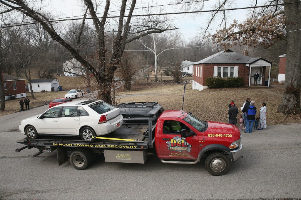 A car on a tow truck getting towed