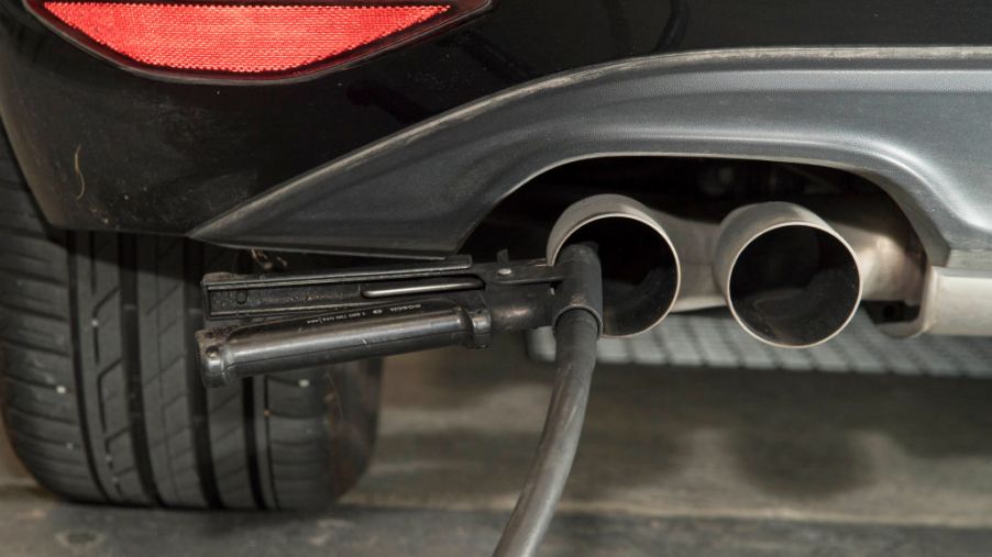 A hose for an emissions test is placed in the exhaust pipe of a vehicle