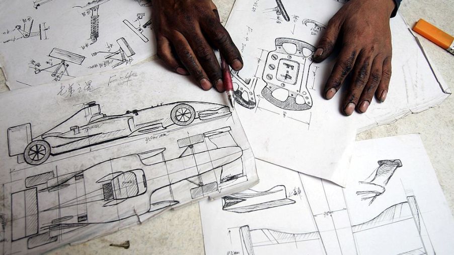 Car design blueprints spread out on a desk