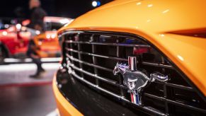 A logo is displayed on the front grille of a Ford Mustang during the 2019 New York International Auto Show