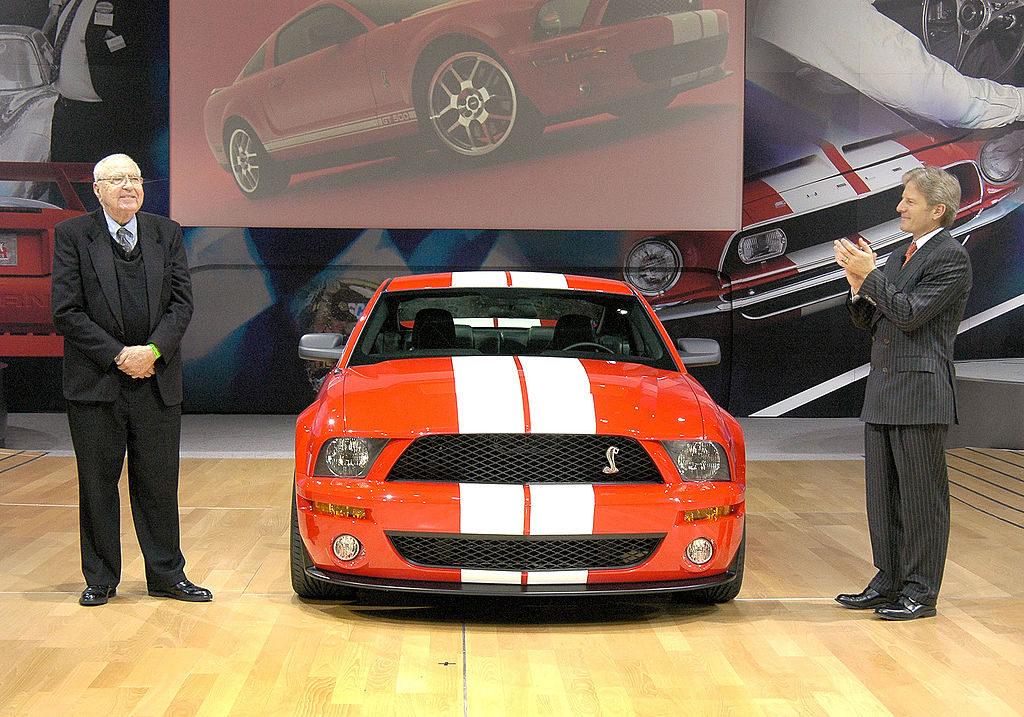 An orange Ford Mustang with racing stripes