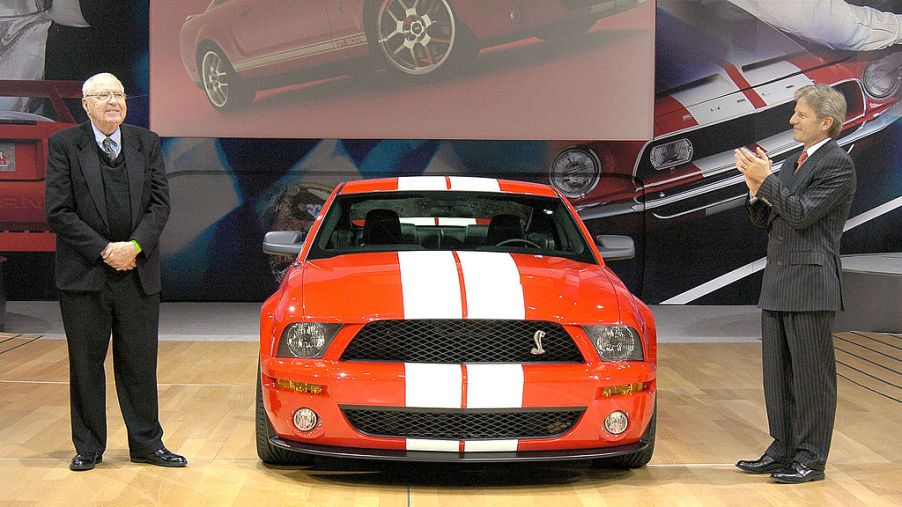 An orange Ford Mustang with racing stripes