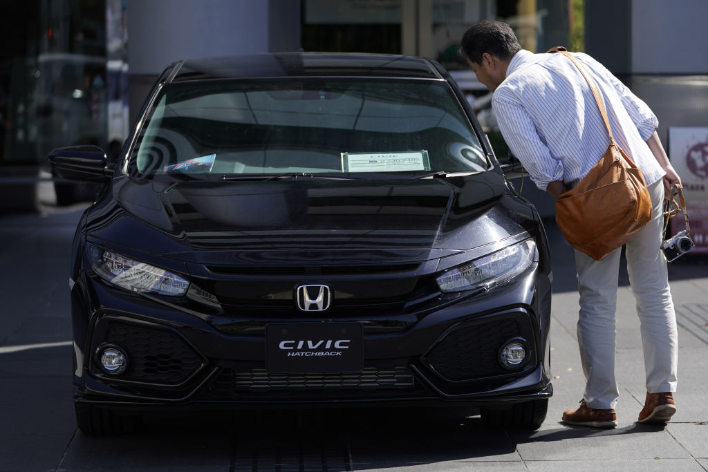Man inspecting a black Honda Civic