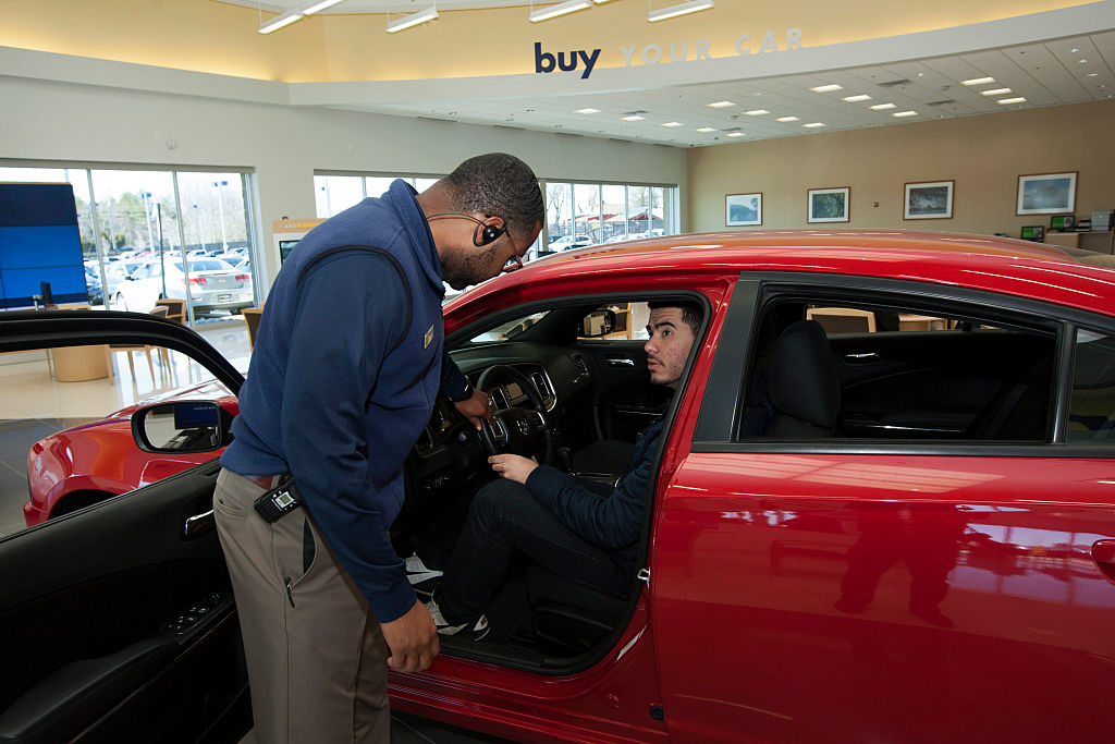 Finance and sales manager Warren Cox speaks with a customer about a Dodge Charger