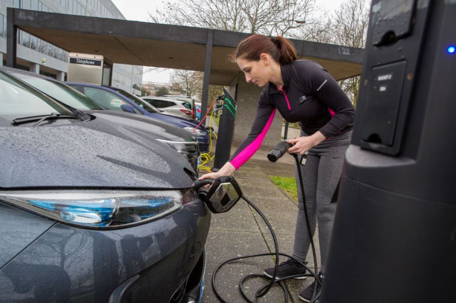 Woman charging a used electric car