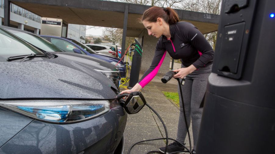 Woman charging a used electric car