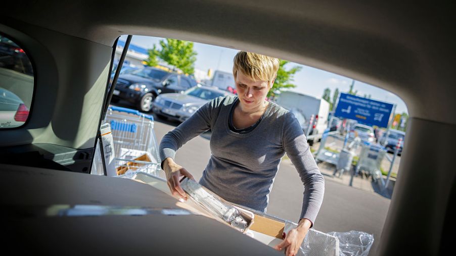 A woman stores items in her car