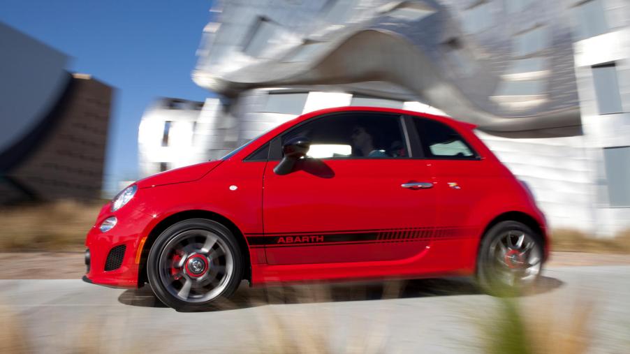 A red FIAT 500 Abarth zips around a curve.