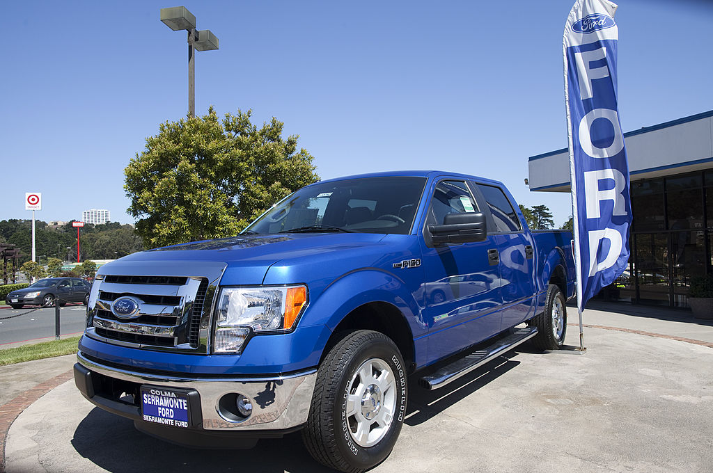 a blue 2011 ford f-150 on display at an auto dealership