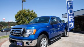 A blue 2011 Ford F-150 on a car dealership's lot.