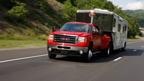 The 2013 GMC Sierra 3500 HD SLT pulls a horse trailer on a highway