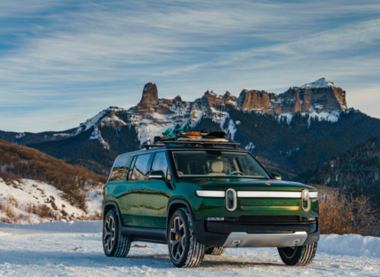 a green electric SUV in the snow