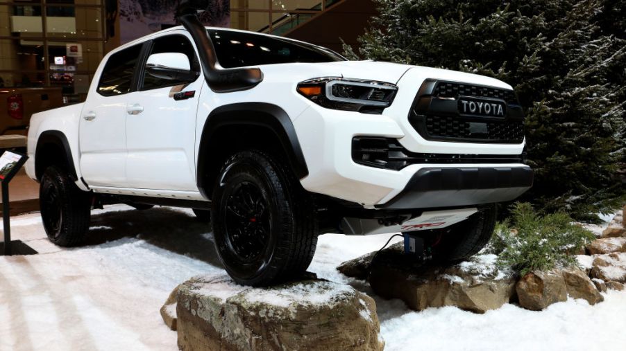 A white 2020 Toyota Tacoma on display at an auto show.