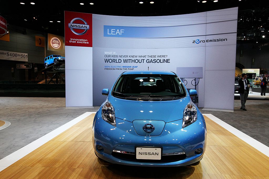 A blue Nissan Leaf on display at an auto show.