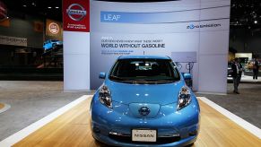 A blue Nissan Leaf on display at an auto show.