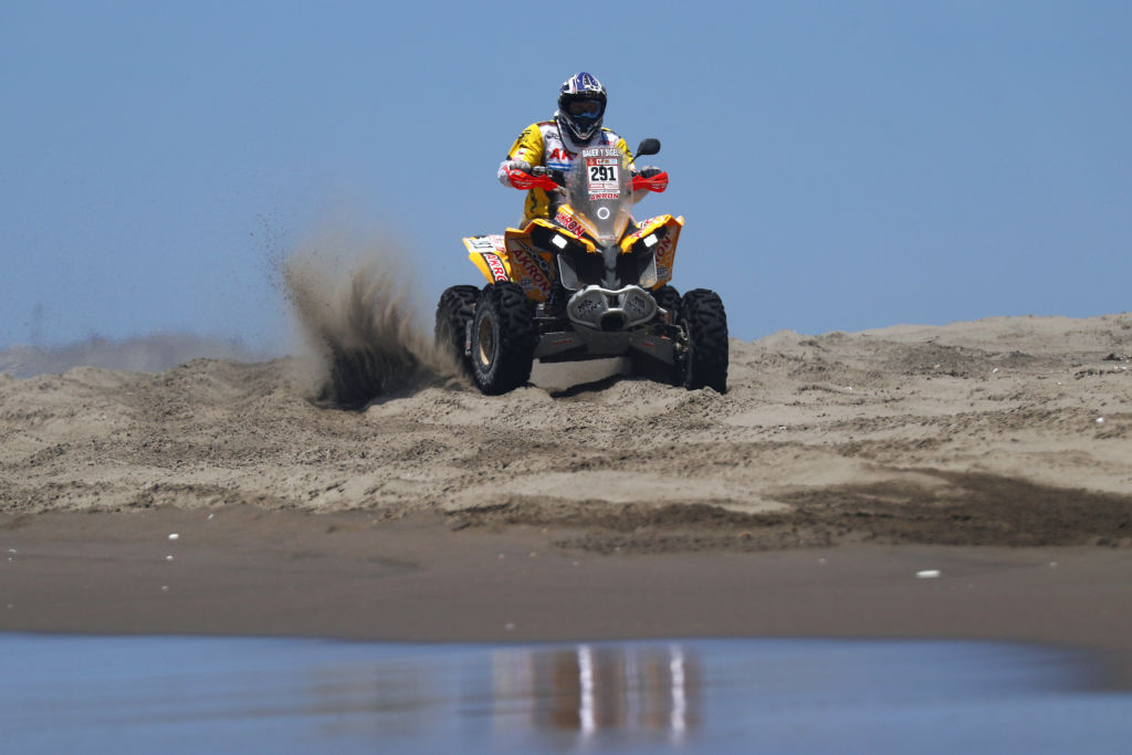 an ATV in soft sand shows someone riding hard–one reason for the most common ATV problems