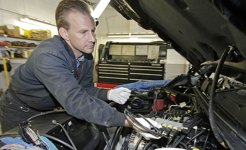 A mechanic inspecting the engine of a Chevy Silverado