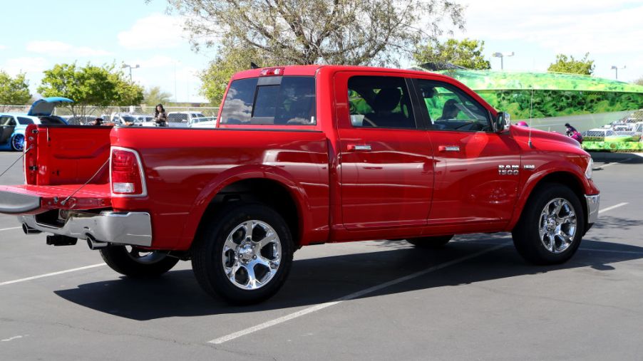 A red Dodge Ram in a parking lot with the tailgate dropped.