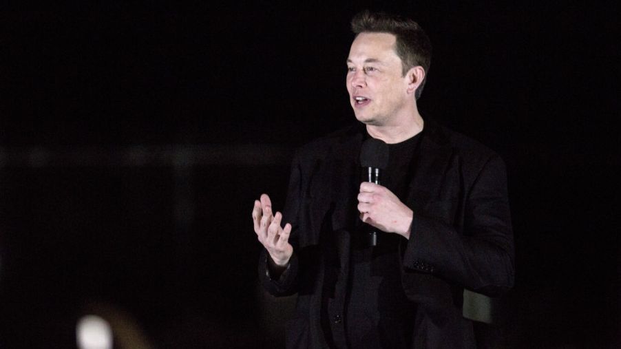 Tesla CEO Elon Musk gives a presentation on stage.
