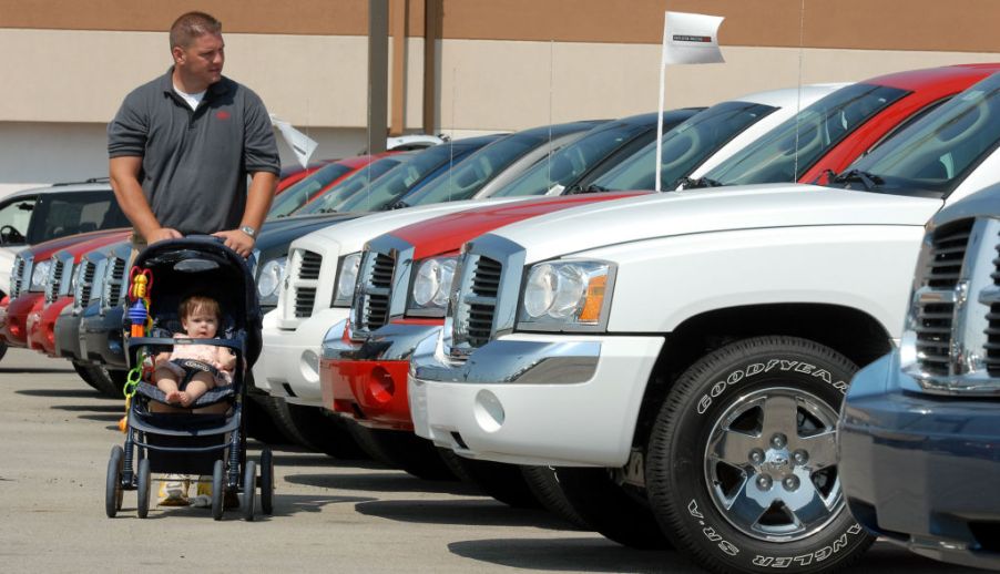 James Stout pushes his 10-month-old daughter Allison in a stroller as he shops for a Dodge Dakota in 2006