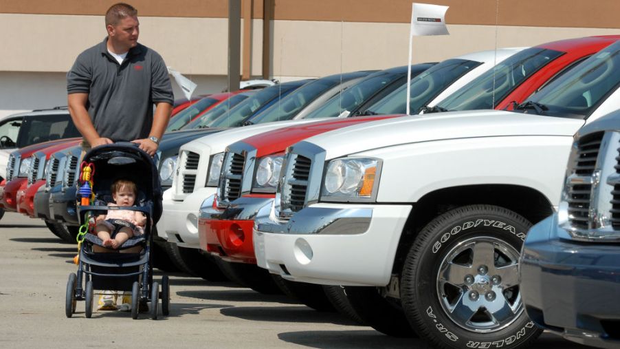 James Stout pushes his 10-month-old daughter Allison in a stroller as he shops for a Dodge Dakota in 2006