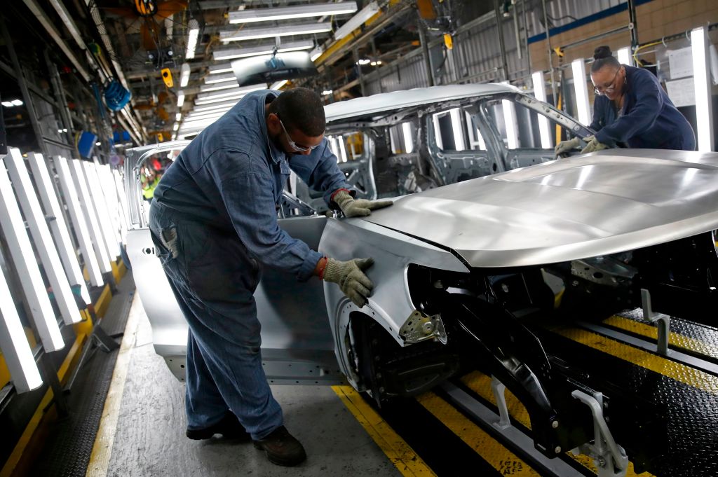Workers assemble cars at the newly renovated Ford's Assembly Plant in Chicago