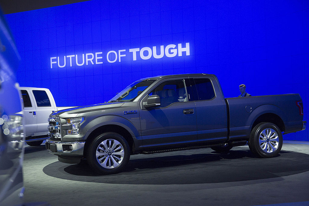 A blue Ford F-Series truck on display at an auto show.